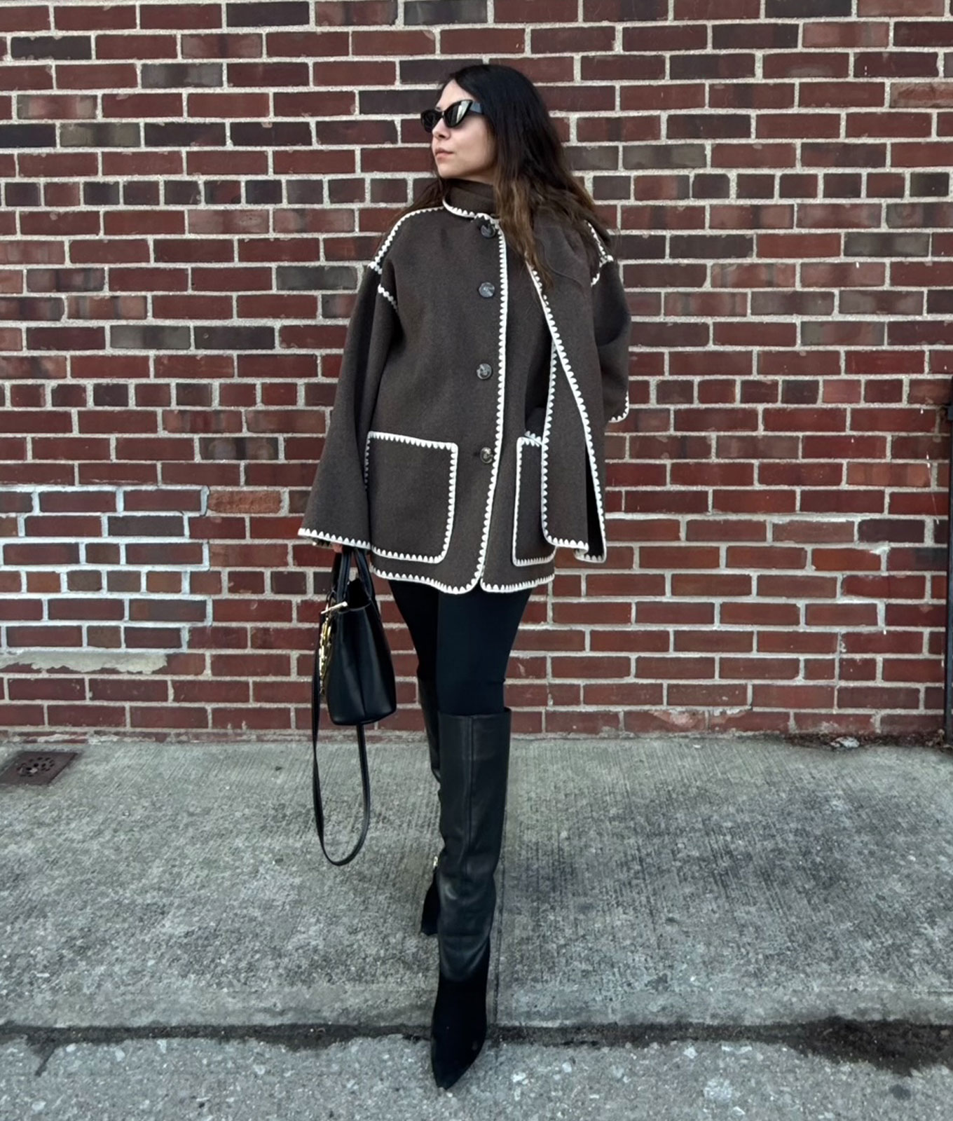 How to wear leggings in 2026: original photo of PureWow editor Stephanie Maida in brown scarf coat and leggings