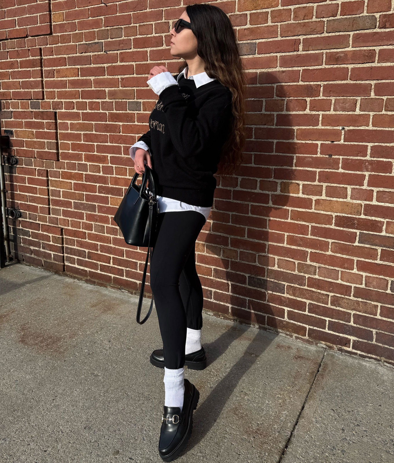 How to wear leggings in 2026: original photo of PureWow editor Stephanie Maida in black sweater, white button-down and leggings