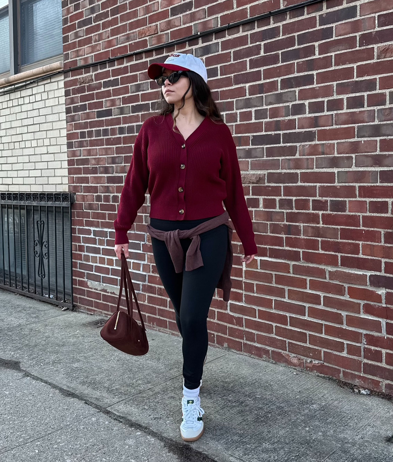How to wear leggings in 2026: original photo of PureWow editor Stephanie Maida in burgundy cardigan and leggings
