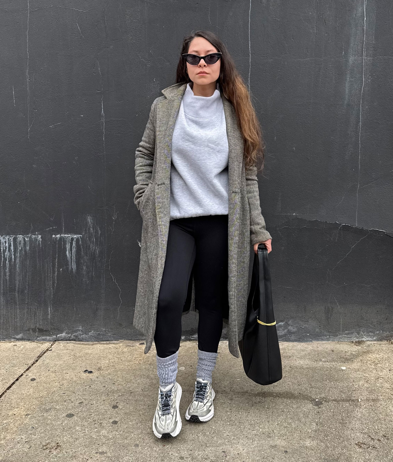 How to wear leggings in 2026: original photo of PureWow editor Stephanie Maida in gray sweatshirt, long gray coat and leggings