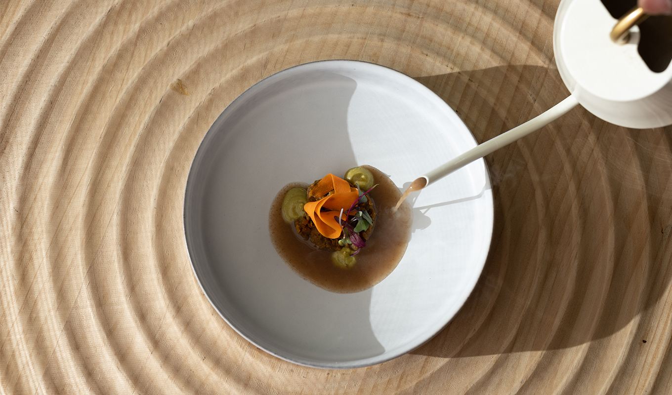 Solo Dining in Los Angeles: Nigerian dish with carrot garnish and broth being poured over at Ilé