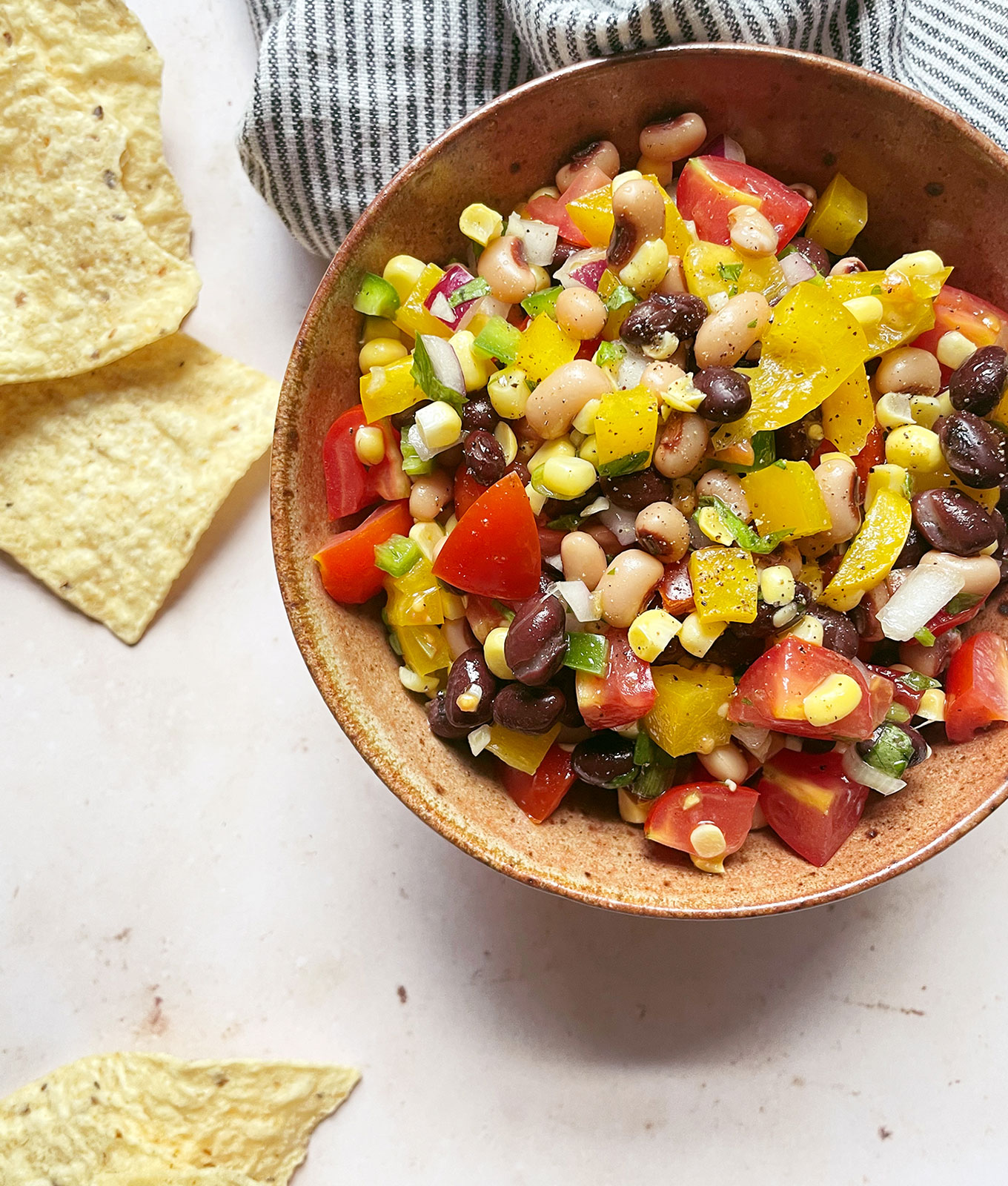 jalapeño recipes: cowboy caviar in a bowl with tortilla chips on a counter