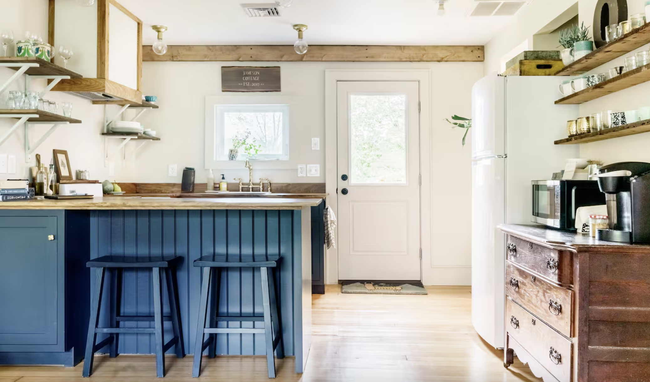romantic airbnb with exposed wood beams and a blue kitchen island