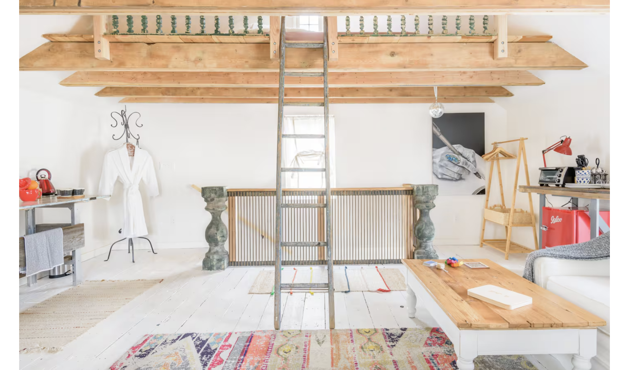 romantic airbnb with exposed wood beams and a ladder to the loft