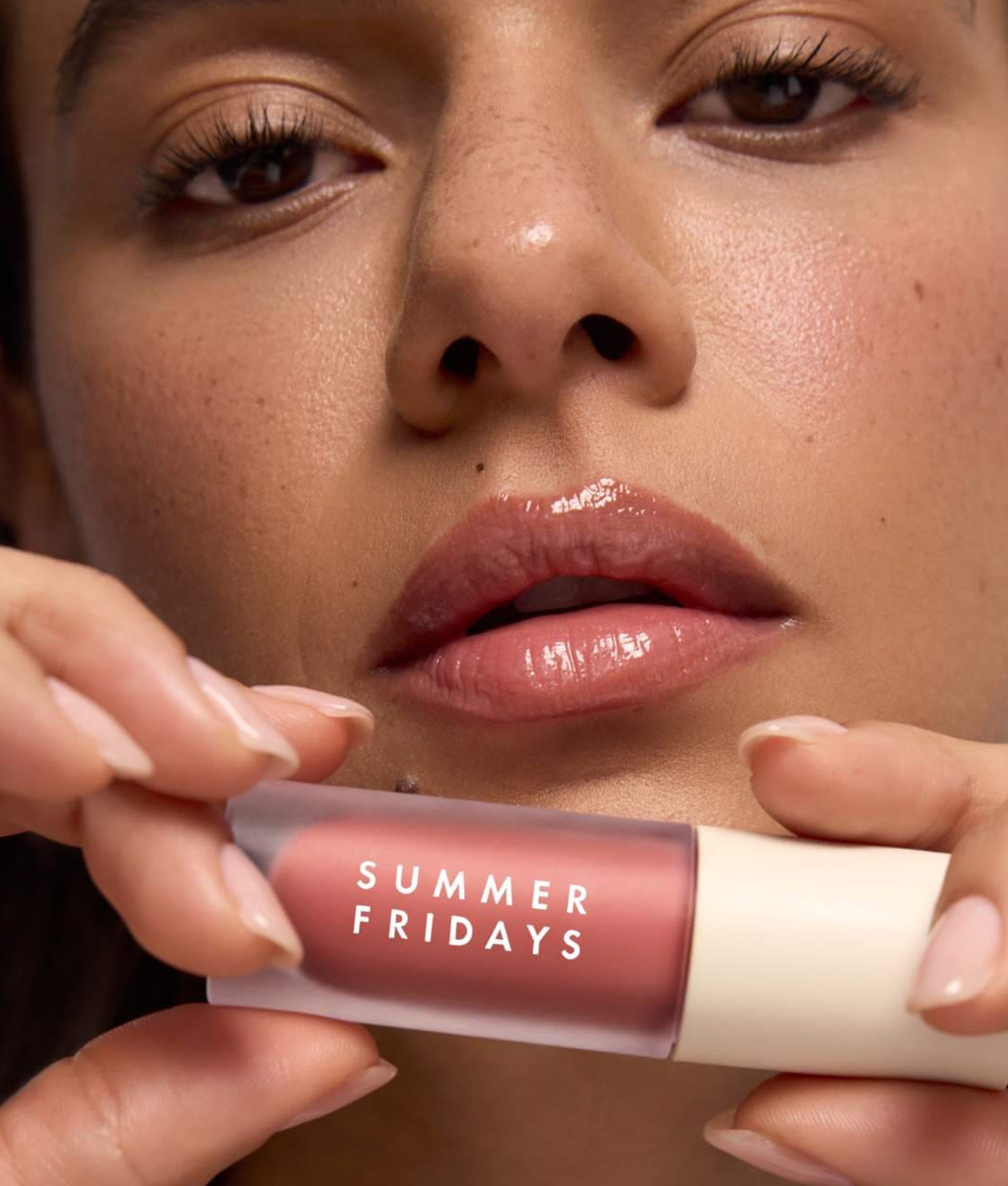 Model holding summer fridays lip oil on sale for black friday teen beauty