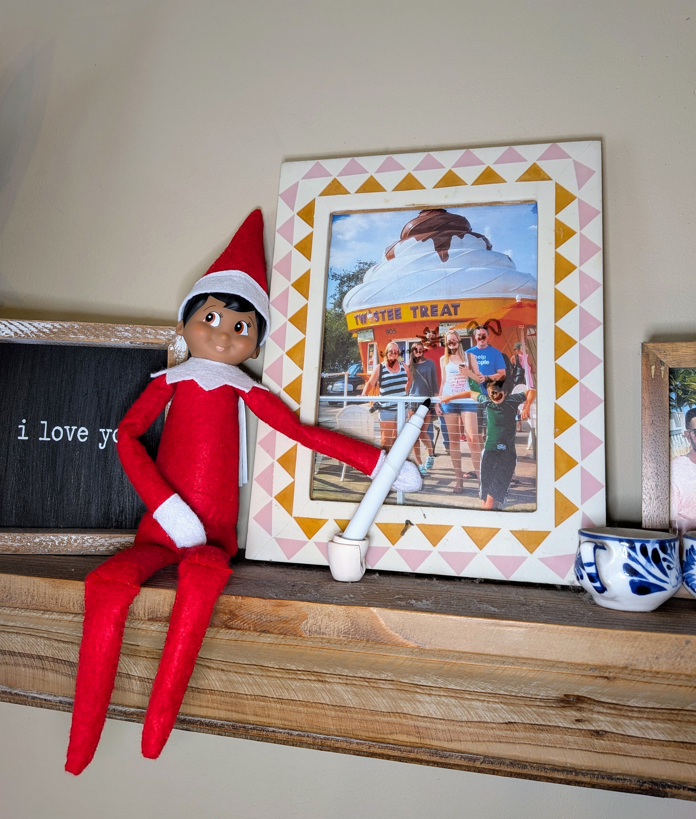 elf with dry erase marker on framed photo