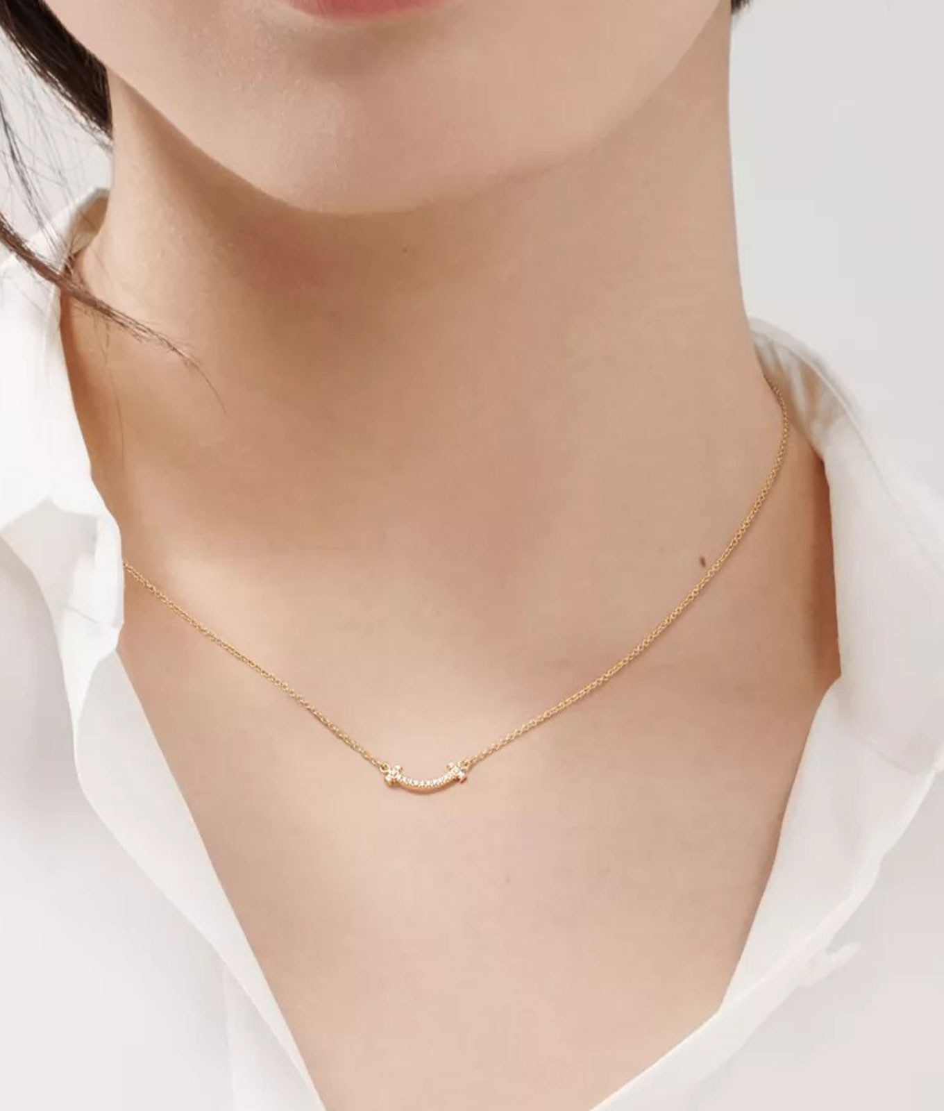 how-to-layer-necklaces-like-a-french-woman: a thin gold necklace with a smile pendant