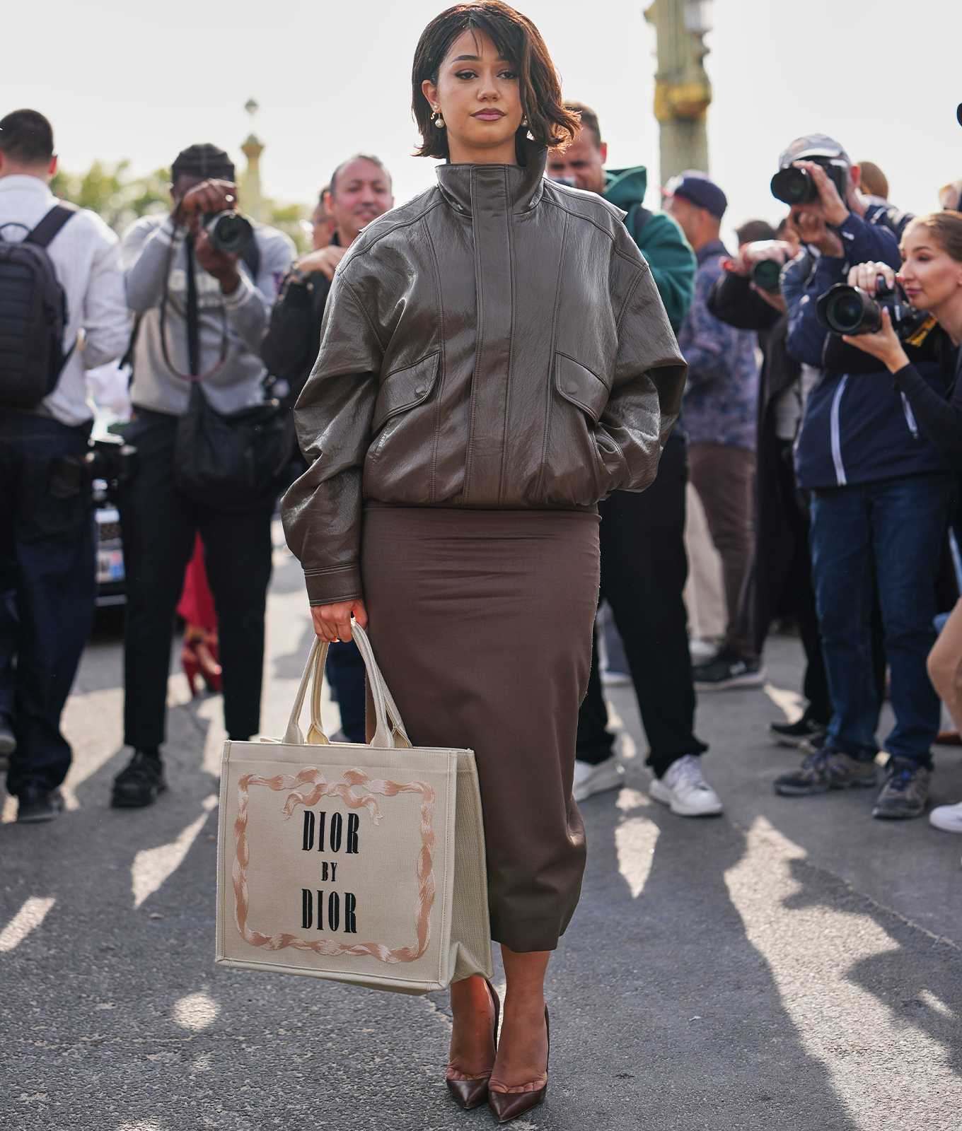 woman wearing a leather bomber jacket with matching skirt