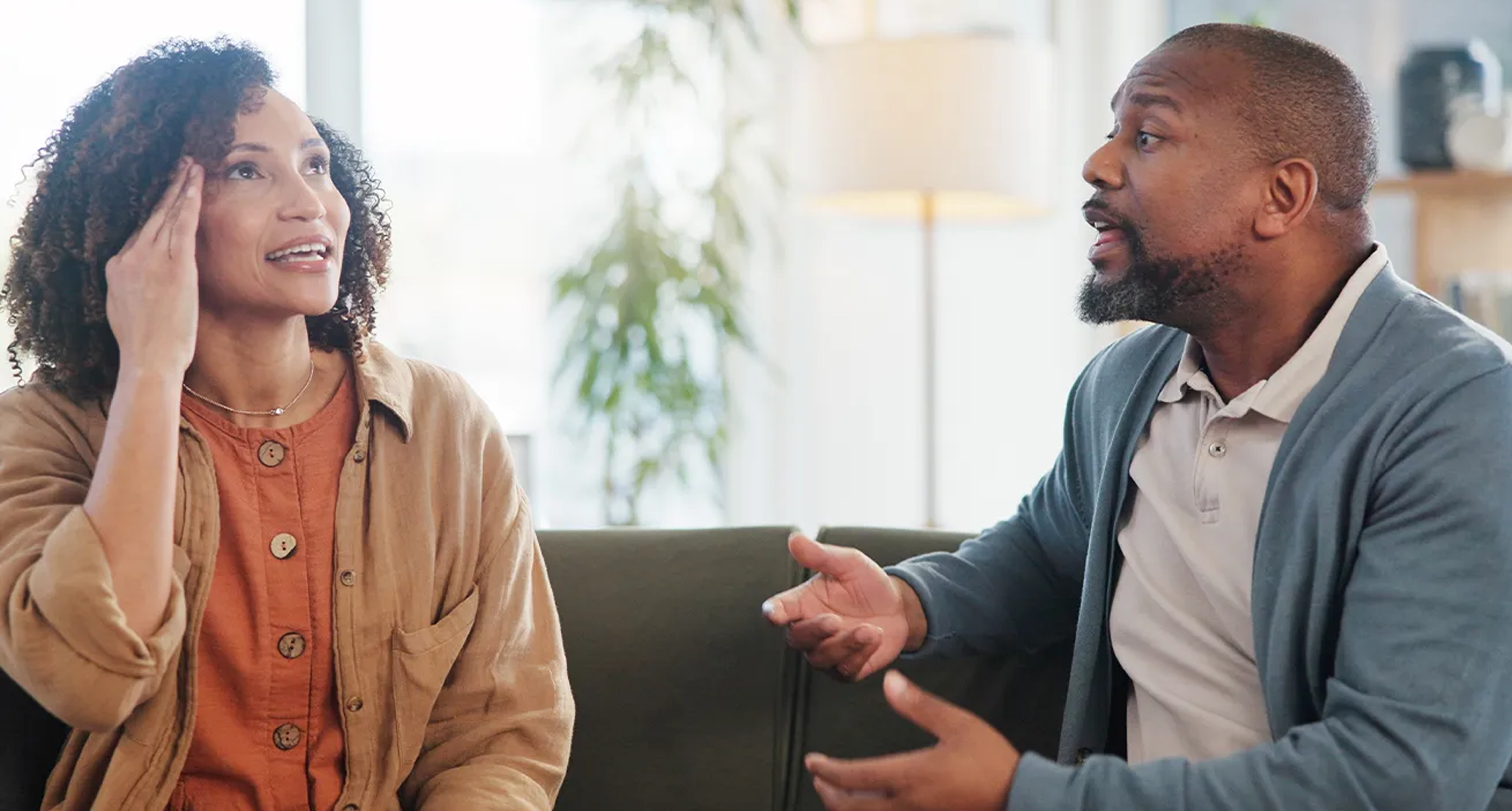 A woman and man arguing, seeming frustrated, on a couch
