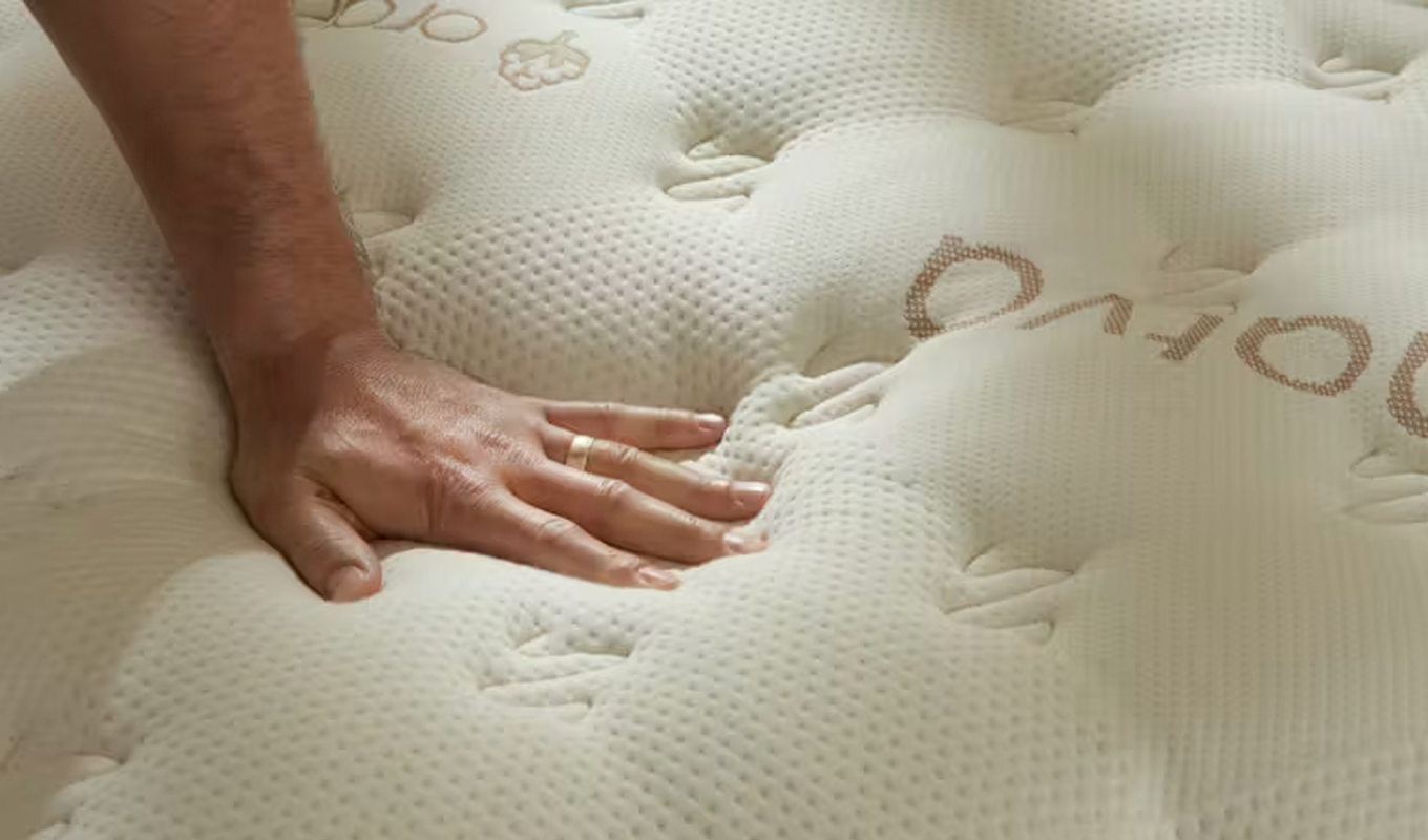 Saatva Classic vs. Helix Midnight Luxe Mattress Review: Saatva Classic hand pressing on cushy mattress top