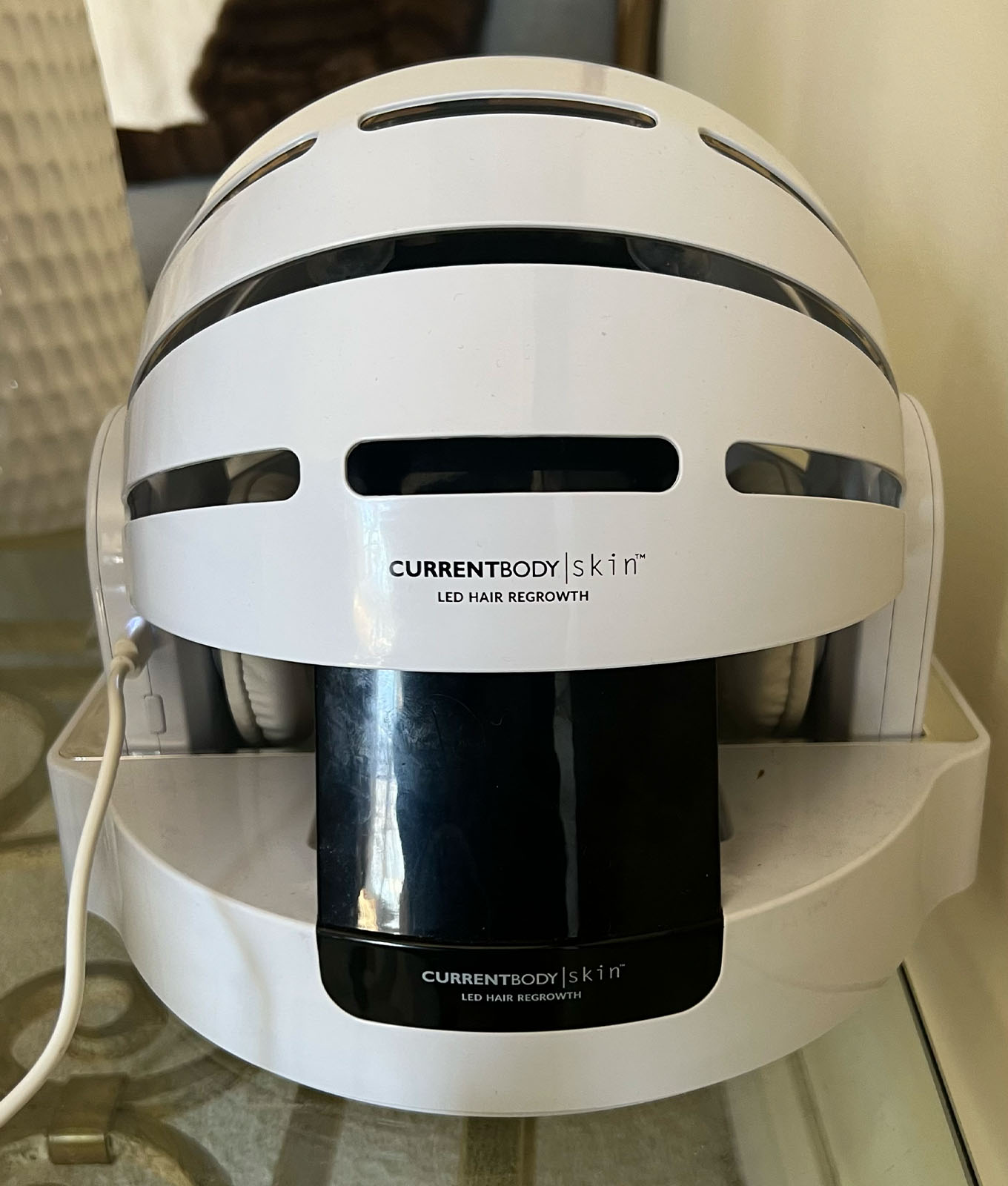 The CurrentBody Skin LED Hair Growth Helmet on the stand.