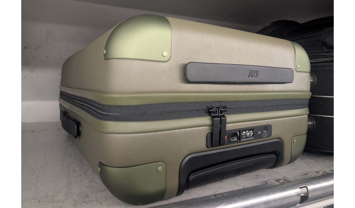 july luggage in overhead bin in airplane