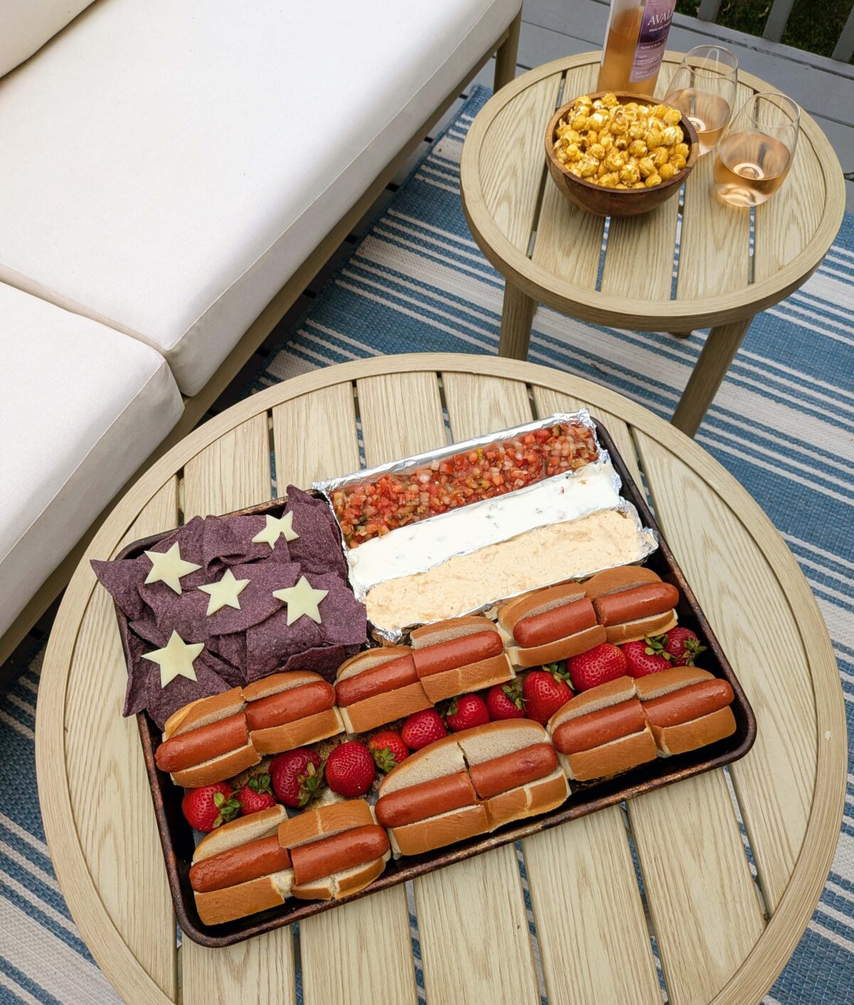outdoor table with rosé and hot dog board for July 4th