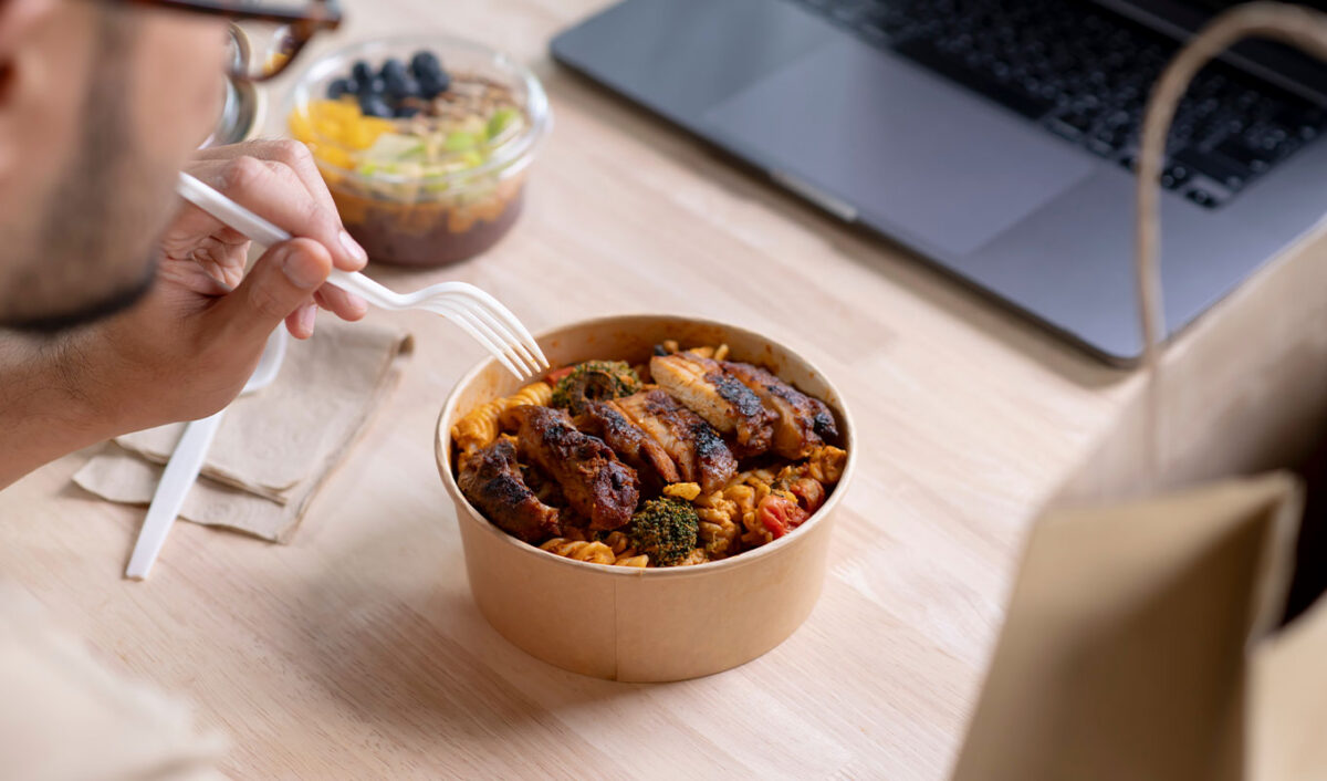 elitist-work-salads: a man eating a meal at a desk
